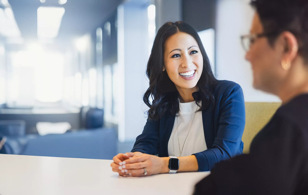 A principal employee meets with a teammate to discuss the latest press release